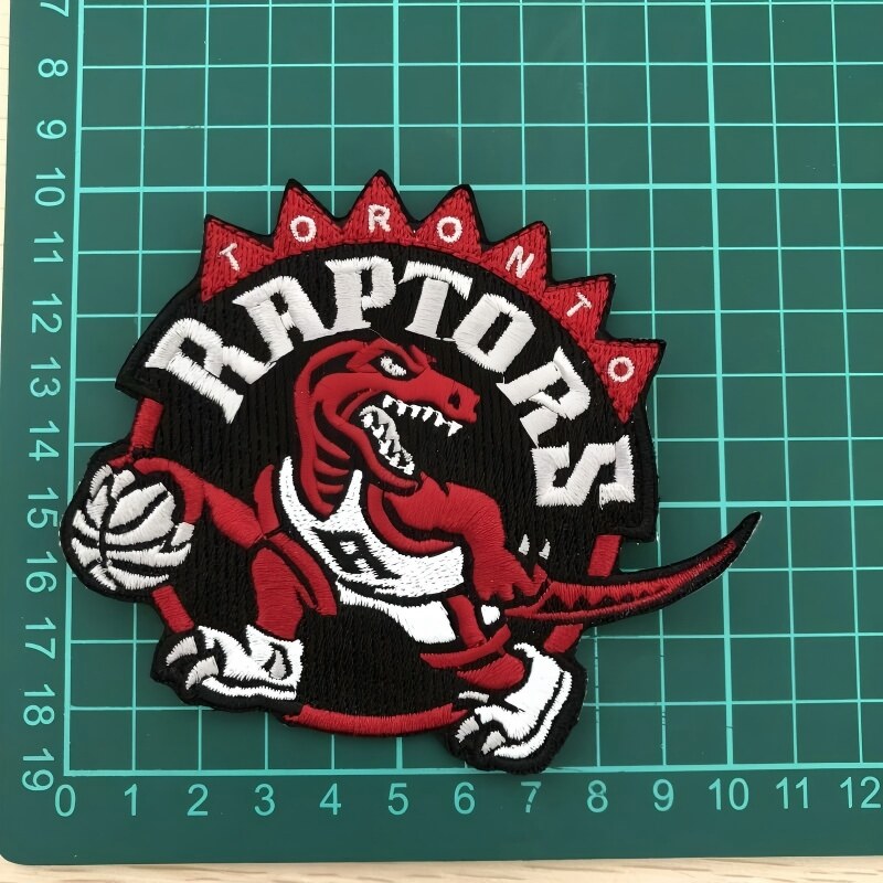 Toronto Raptors red dinosaur basketball mascot embroidered patch on green cutting mat with ruler