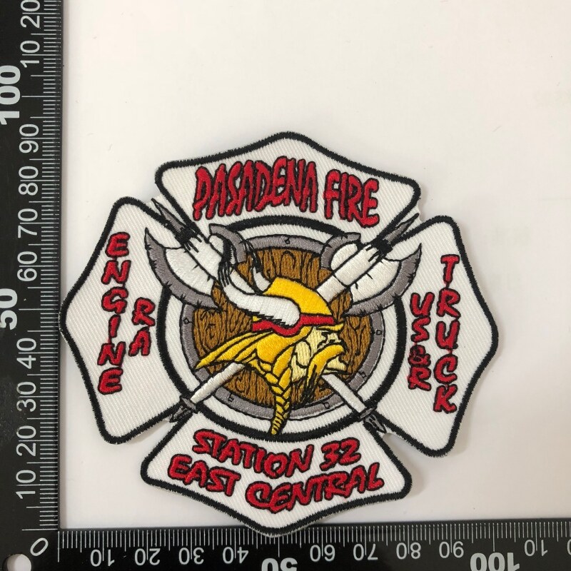 Fire department badge with crossed axes and helmet