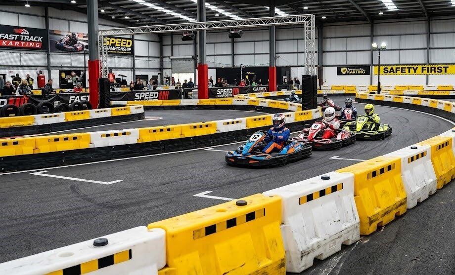 Shock-absorbing modular HDPE safety barrier system designed for high-impact indoor tracks