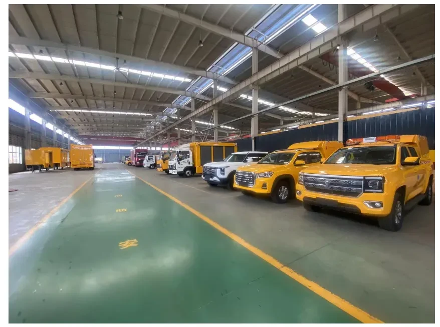Rows of yellow emergency rescue and engineering vehicles parked inside the workshop.