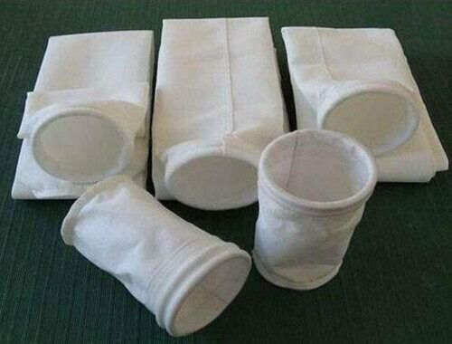 White envelope and round dust collector filter bags with sewn cuffs laid out for media comparison
