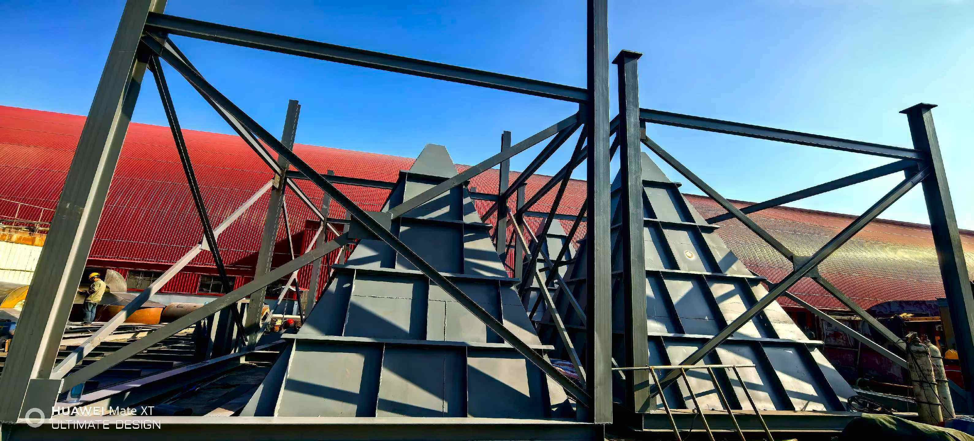 Grey pyramid capture hood canopies aligned on a steel support frame above the furnace roof