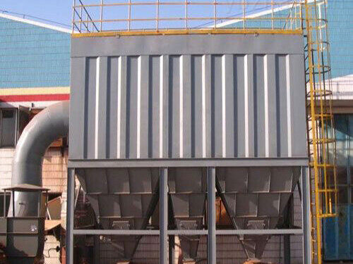 Pulse jet baghouse with ribbed casing and pyramid hoppers on a steel frame beside the plant building