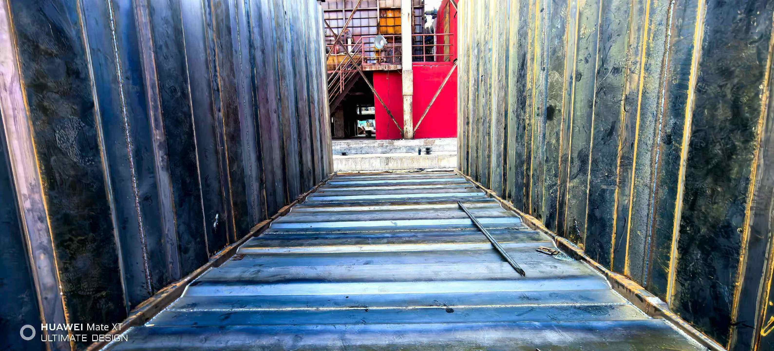 Interior view of a large rectangular flue duct with ribbed steel wall plates before closing