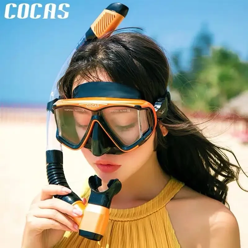 Scene of wearing a COCAS orange snorkel mask and snorkel on the beach