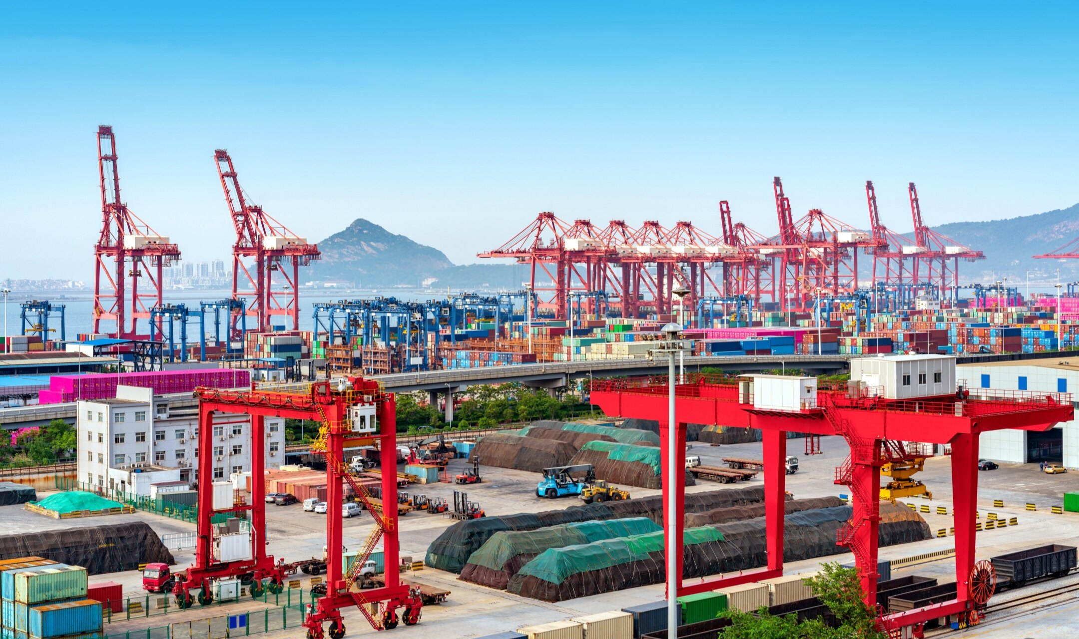 Container port terminal with gantry cranes and stacked cargo containers