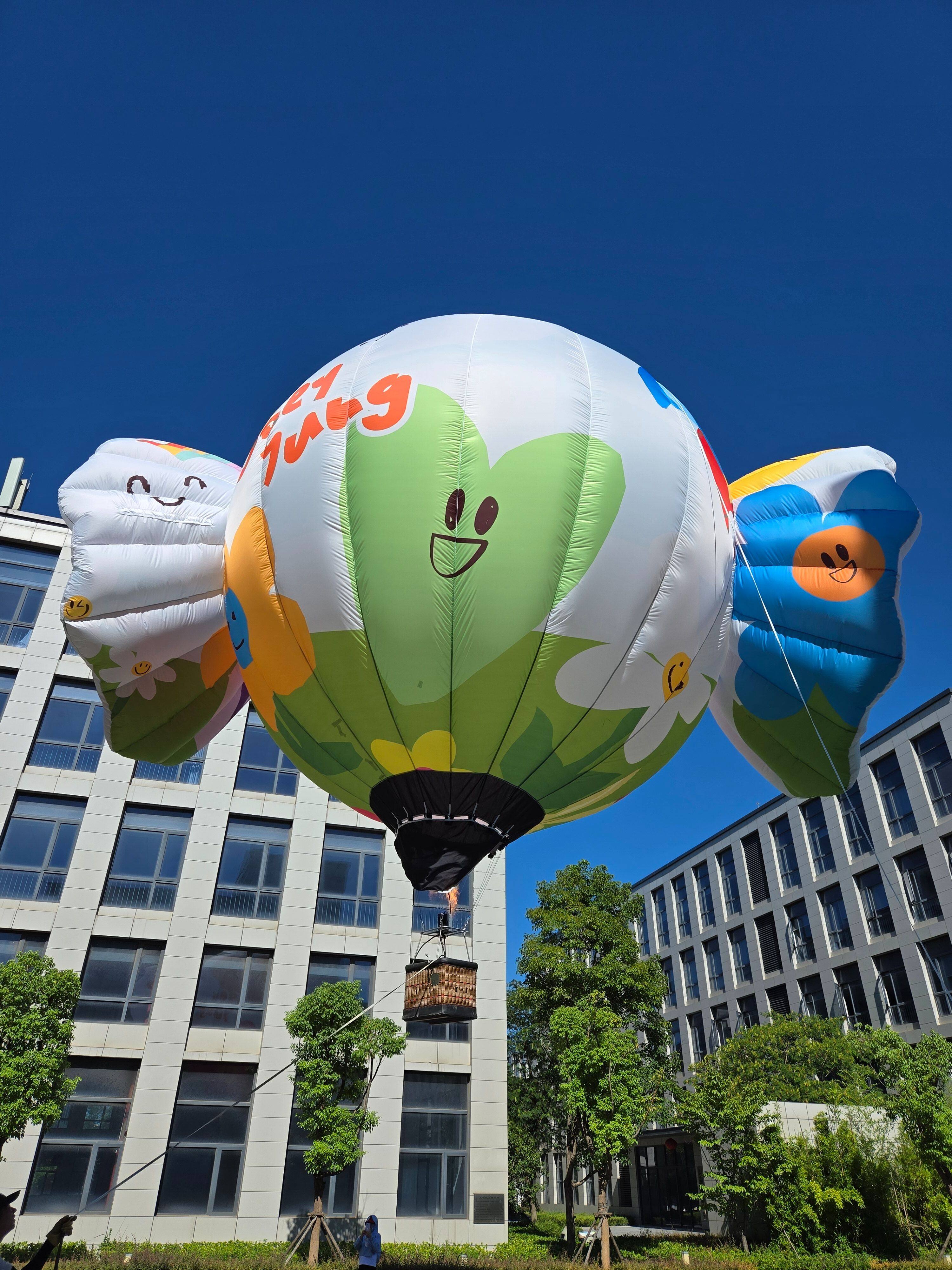 Flower-Shaped Remote-Controlled Hot Air Balloon – Green and white design with colorful petals, ideal for spring events, flower exhibitions, and scenic area displays.