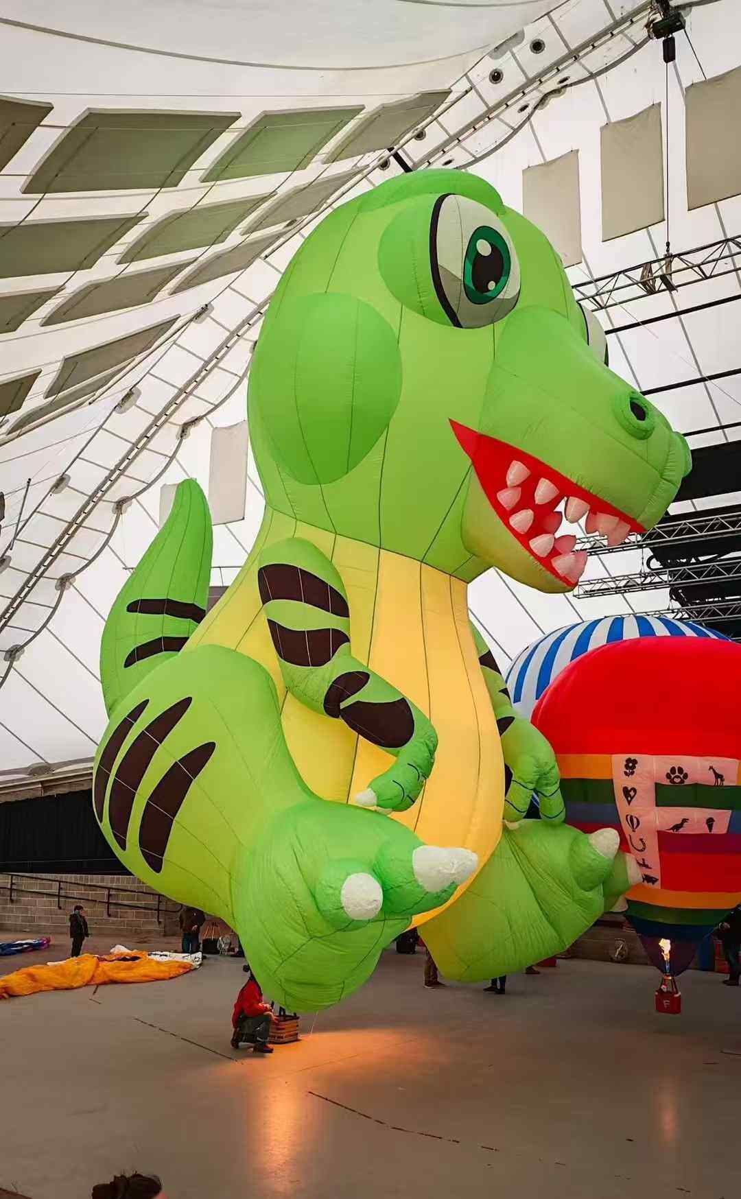 Green T-Rex Shaped Remote-Controlled Hot Air Balloon – A realistic, lifelike green T-Rex remote-controlled hot air balloon displayed indoors, ideal for dinosaur-themed exhibitions and science education events.