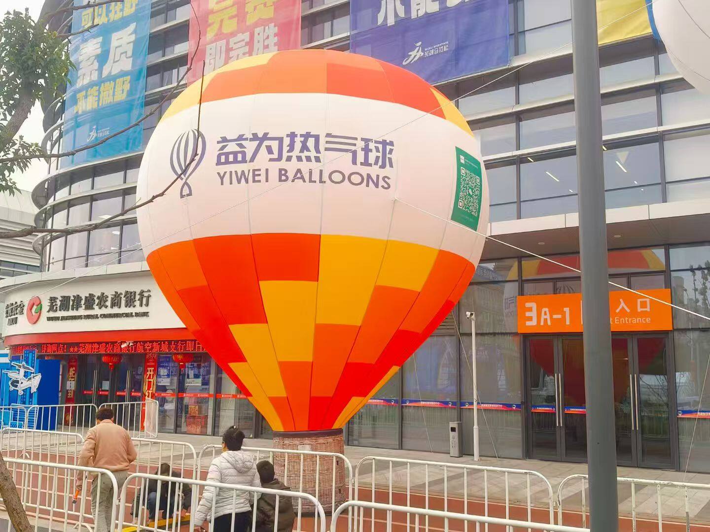 Yiwei Brand Tethered Balloon – Orange, yellow, and white design featuring the "YIWEI BALLOONS" logo. Ideal for brand promotion, trade shows, and commercial marketing.