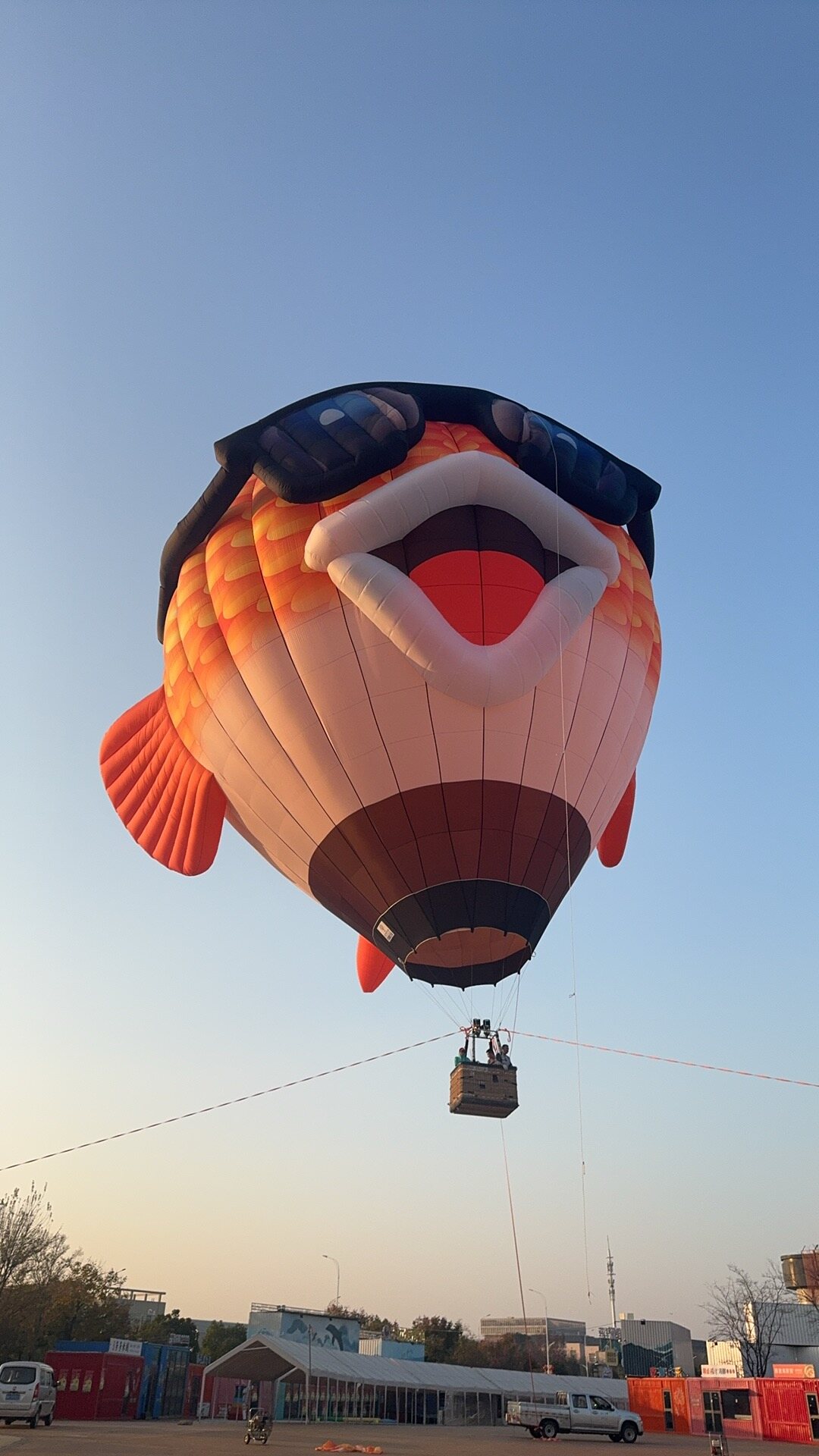 Orange Fish-Shaped Hot Air Balloon – A lively, fun orange fish-shaped hot air balloon wearing sunglasses; perfect for events and brand promotions.