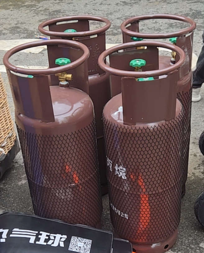Propane Gas Cylinder with Mesh Guard Yiwei Balloons brown propane gas cylinders with mesh protective guard and green valve for balloon flight operations