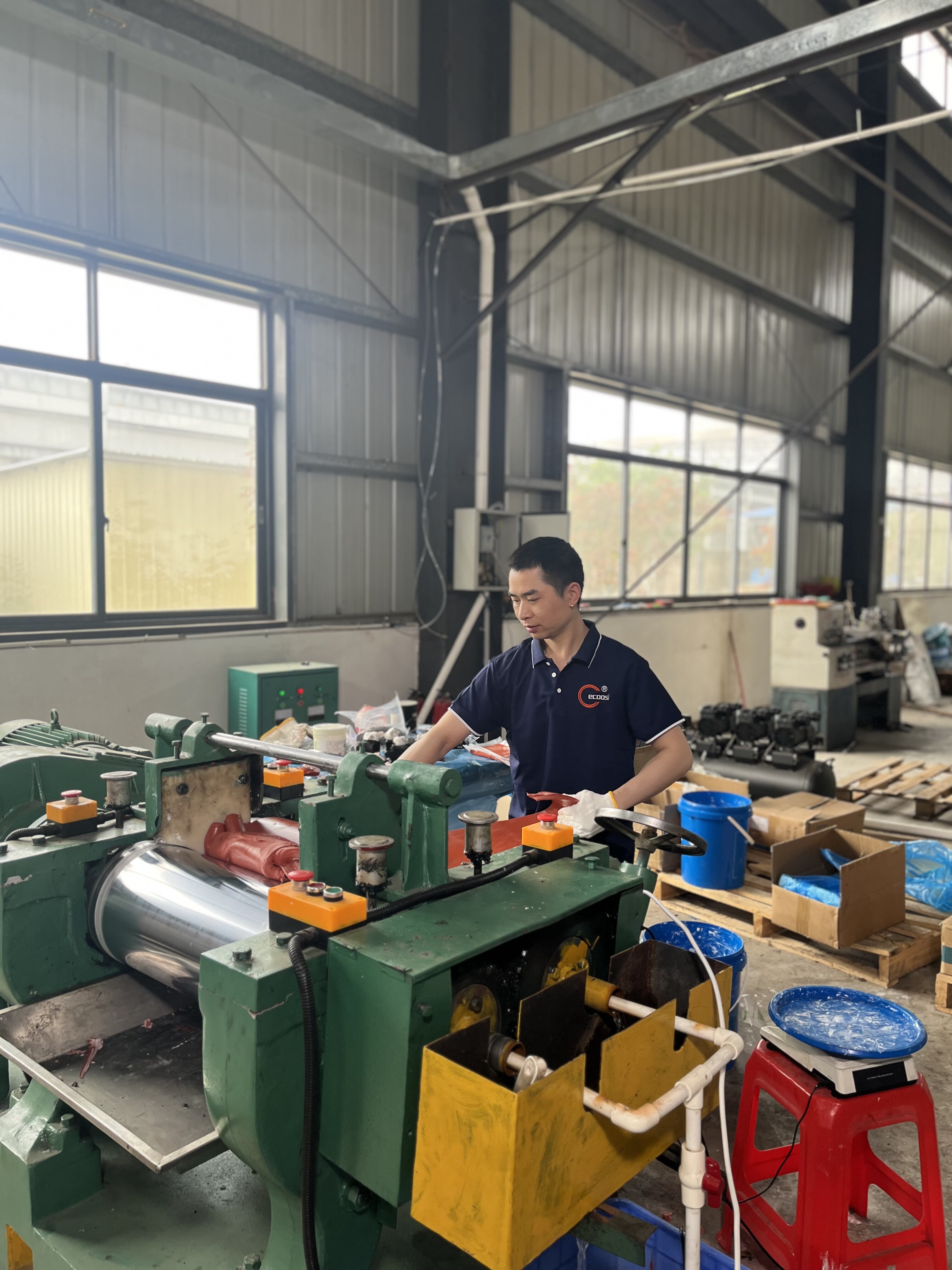 Worker operating industrial rolling machine in factory