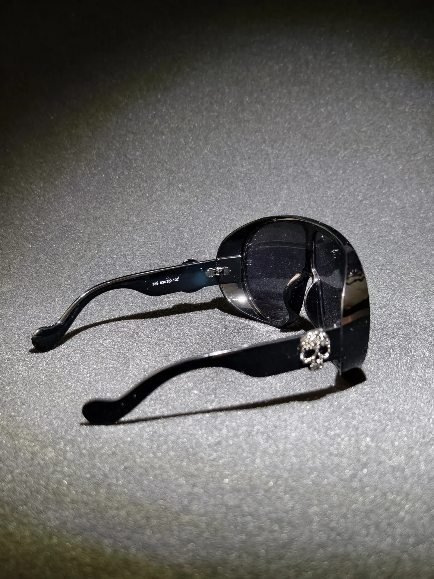 Oval Hinge Skull Shades — Clean oval frame interrupted only by a silver skull at the hinge.