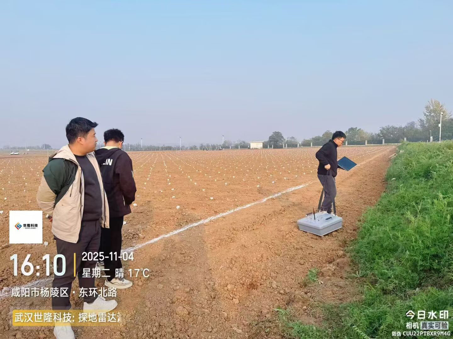 Technician demonstrates ground-penetrating radar operations in a field.