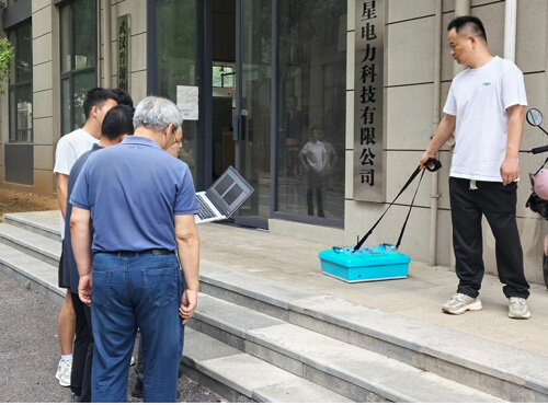 A technician demonstrated the operation of a portable ground-penetrating radar to a North Korean inspection team at the steps outside the company entrance.