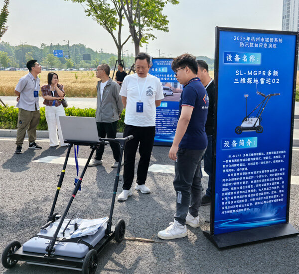 A visitor listens to an explanation in front of the SL-MGPR multi-frequency 3D ground-penetrating radar display panel.