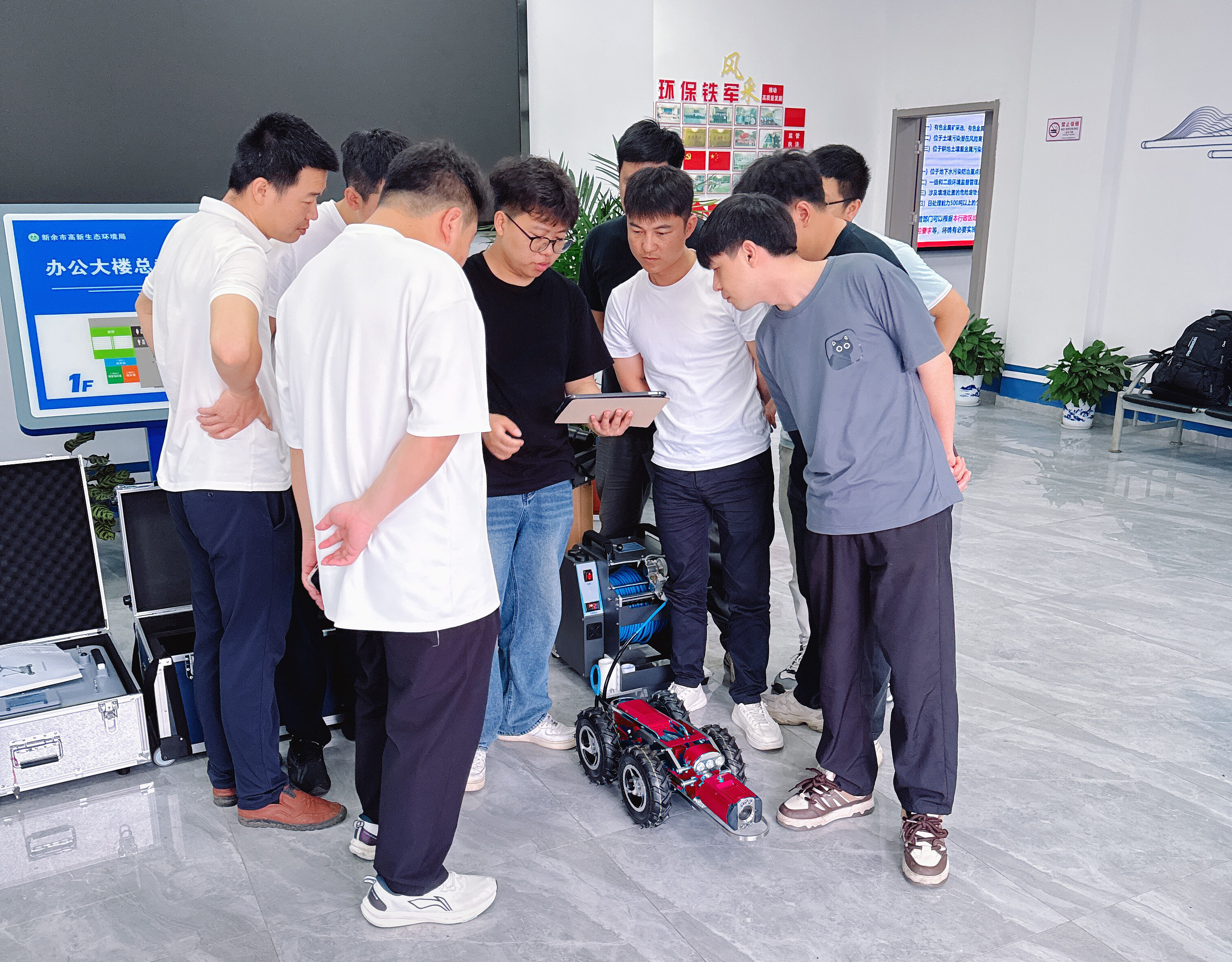 A technical staff member at the Xinyu High-tech Ecological Environment Bureau's main hall explained the operation of the SL-200C pipeline inspection robot to enforcement officers.