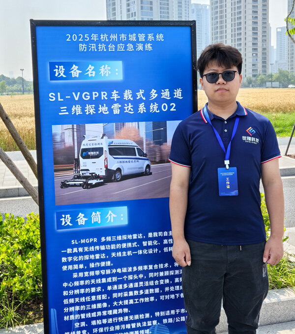 Shilong Technology employee standing in front of the display board for the SL-VGPR vehicle-mounted 3D ground-penetrating radar system.