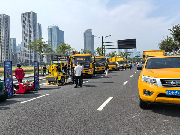 Neatly arranged yellow engineering vehicles at a flood control and typhoon resistance emergency drill site.