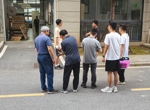 North Korean delegation gathers outside Seelong Technology's factory to hear technicians explain equipment functions.