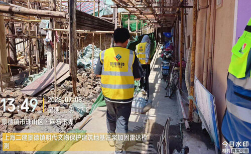 A technician navigates through the alleyways of an ancient building restoration site in Jingdezhen, carrying ground-penetrating radar equipment.