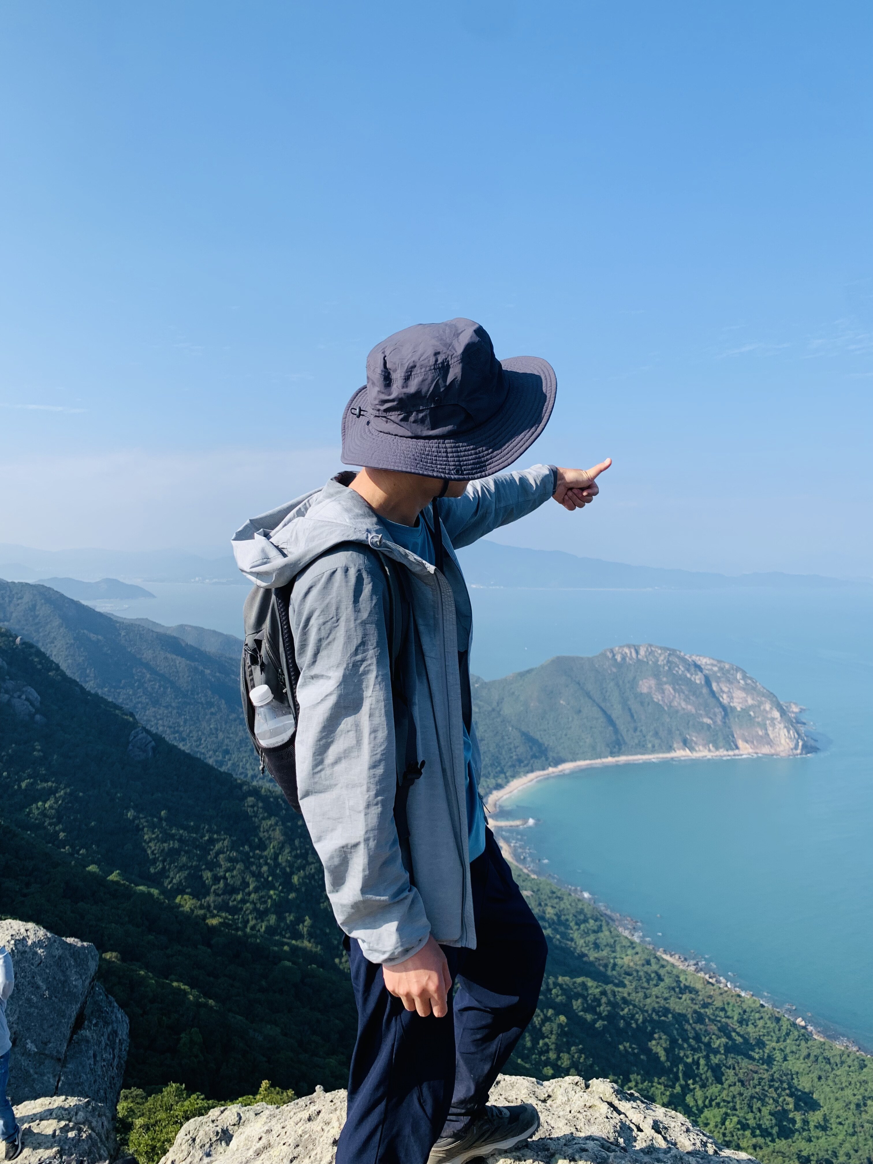 Jacky Liu pointing at Shenzhen coastline from mountain summit