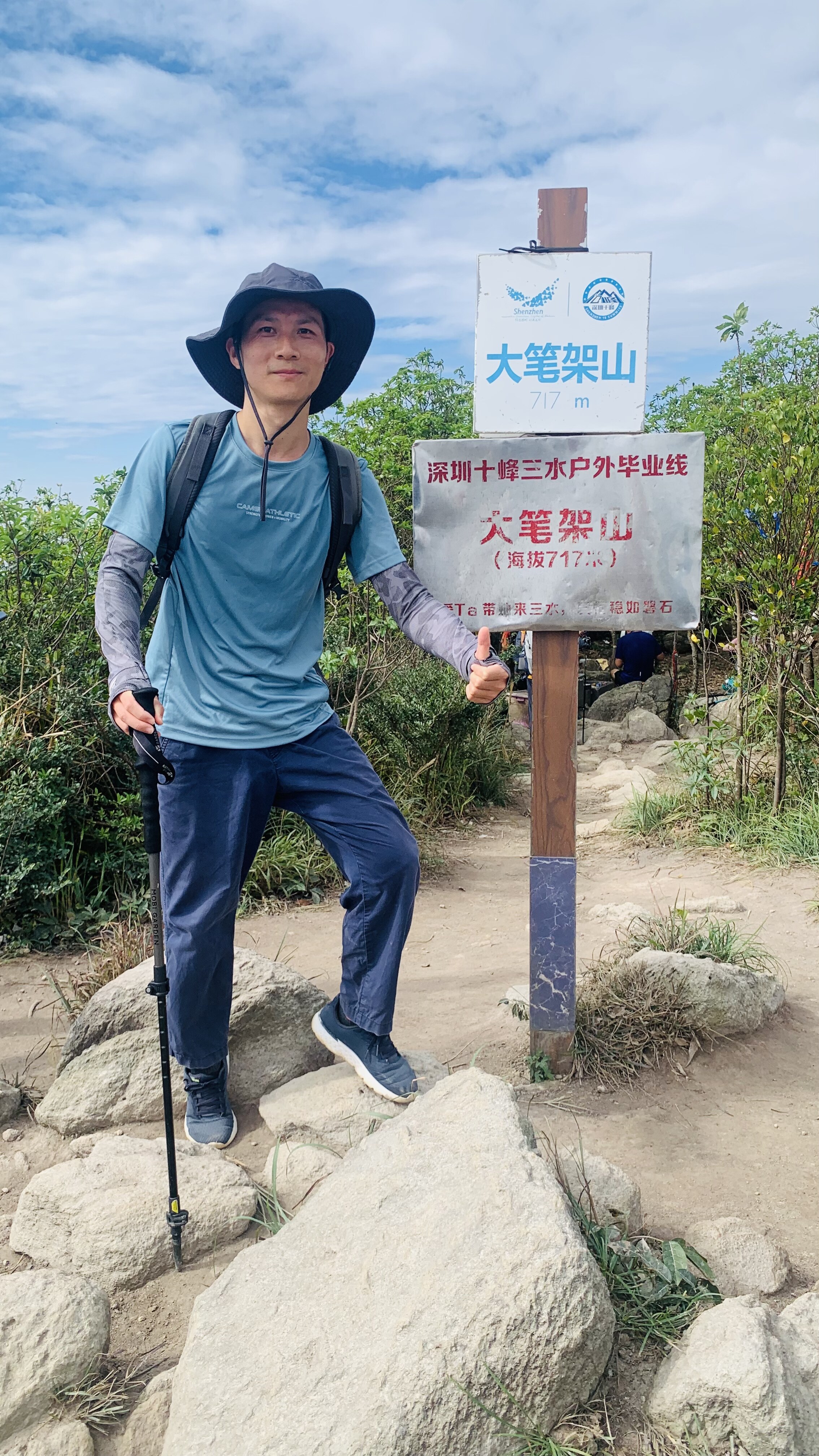 Hiker at Dabijia Mountain 717m marker