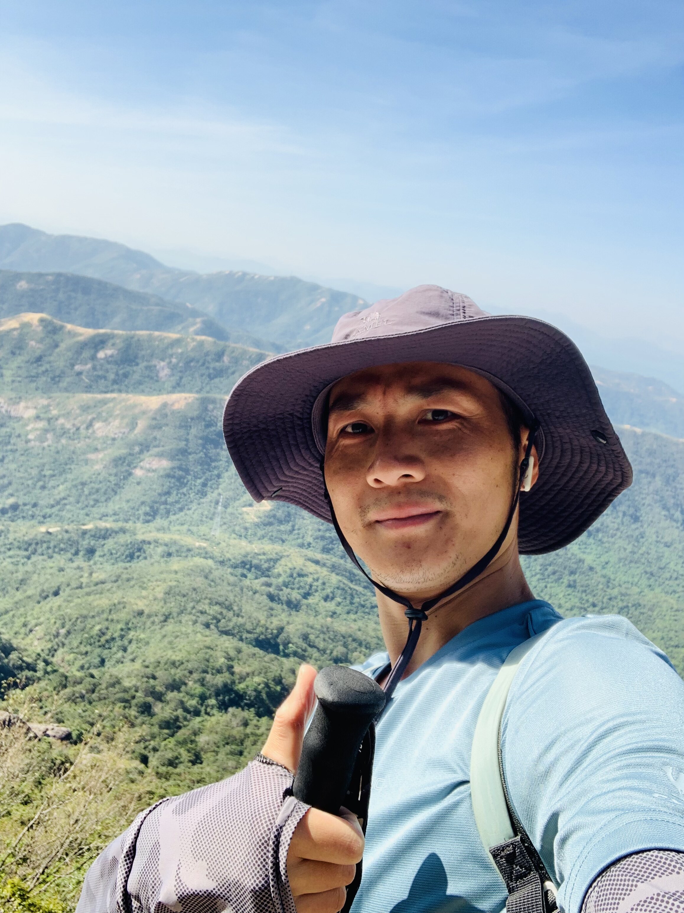 Jacky Liu smiling with mountain and sea background