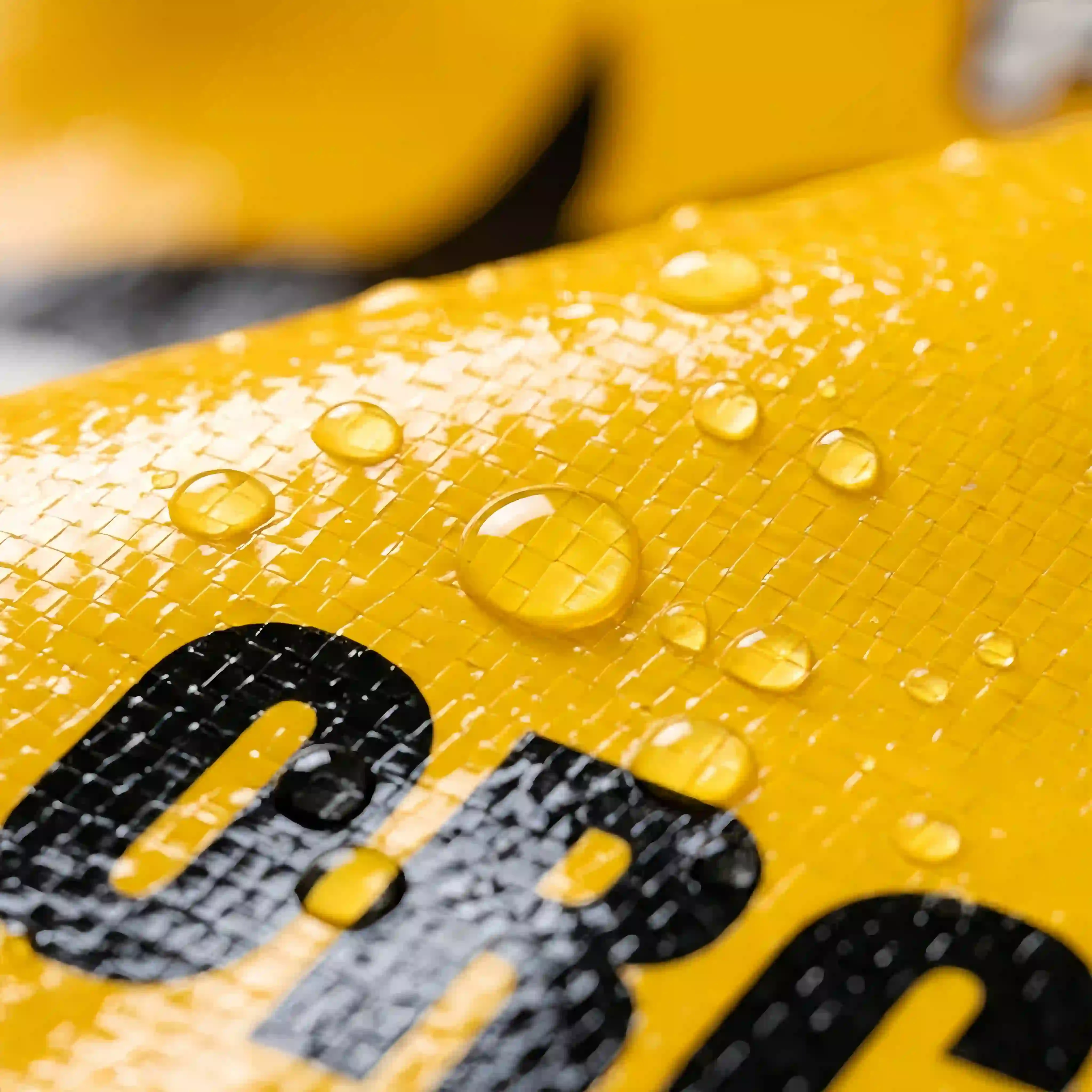 Gravure printing with OPP lamination - Waterproof glossy finish with water droplets on yellow woven bag surface