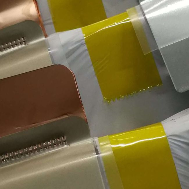 Welded sample secured to metal plate with yellow tape