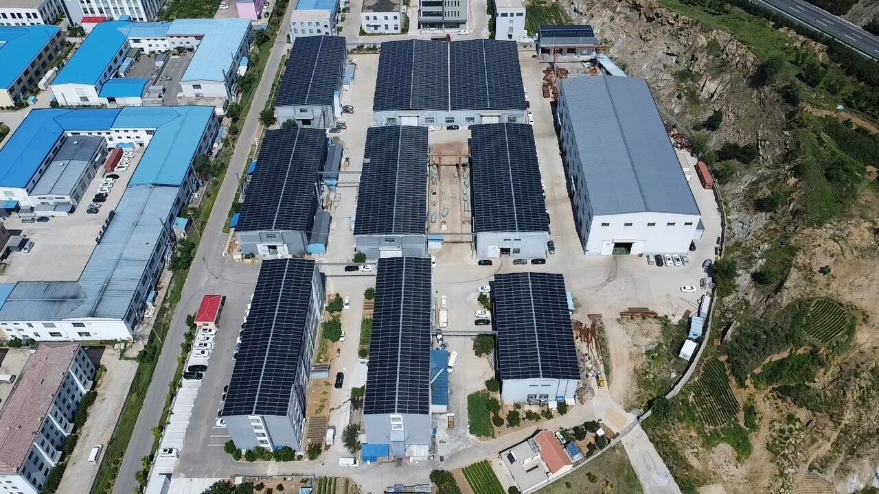 Aerial view of industrial park with multiple buildings featuring rooftop solar installations