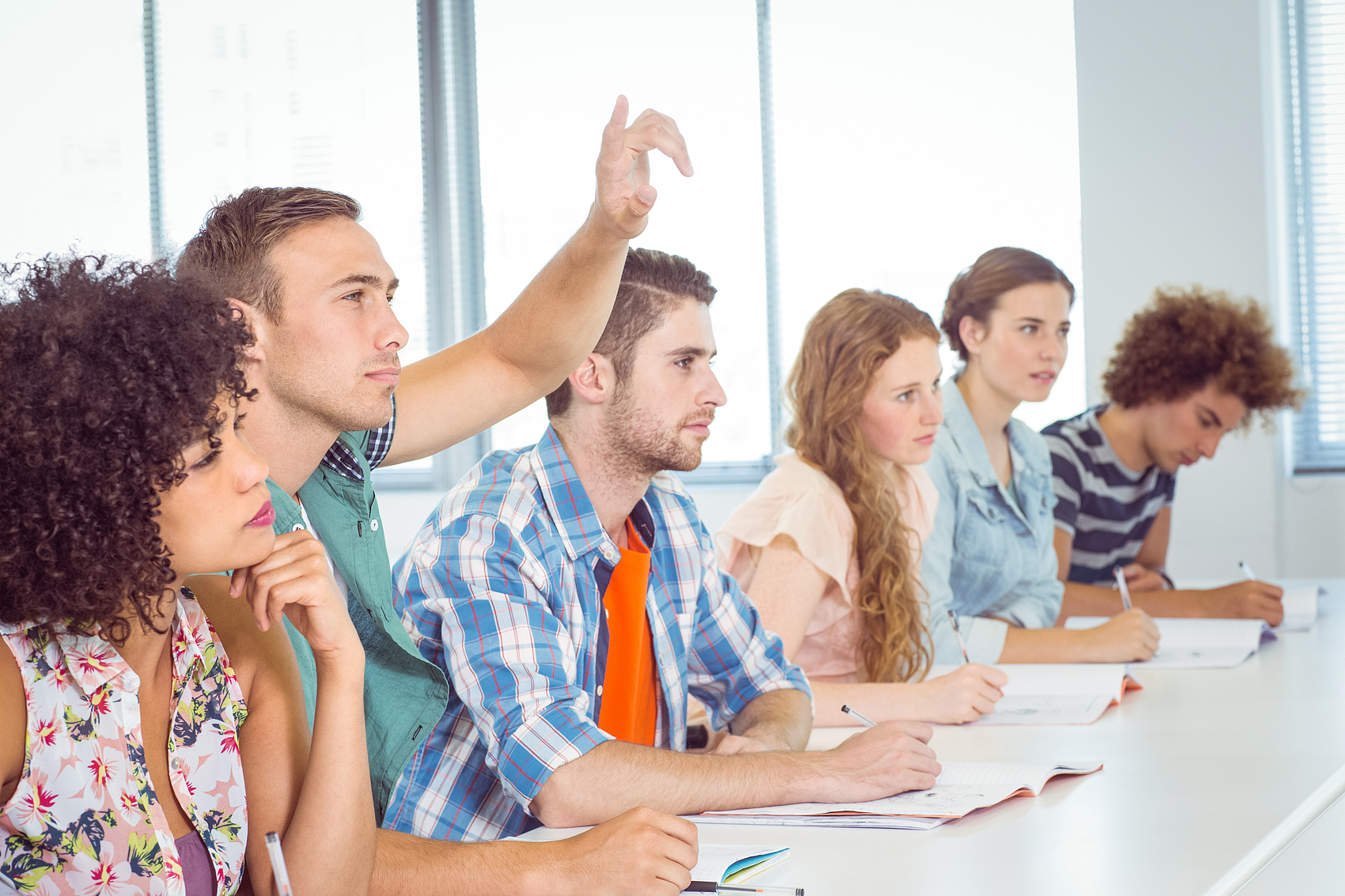 Foreign students raising their hands in class
