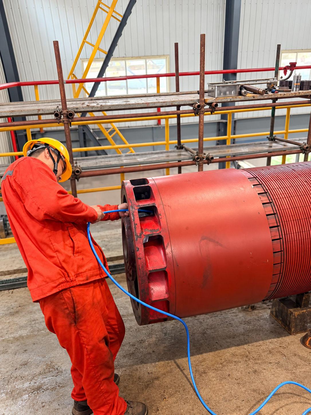 Teknisi membersihkan rotor generator dengan udara tekan