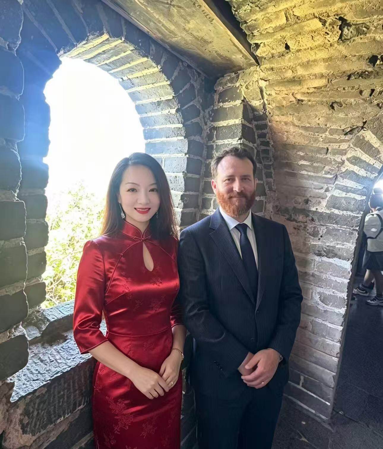 Partners at the Great Wall — red qipao and tailored suit, cultural exchange
