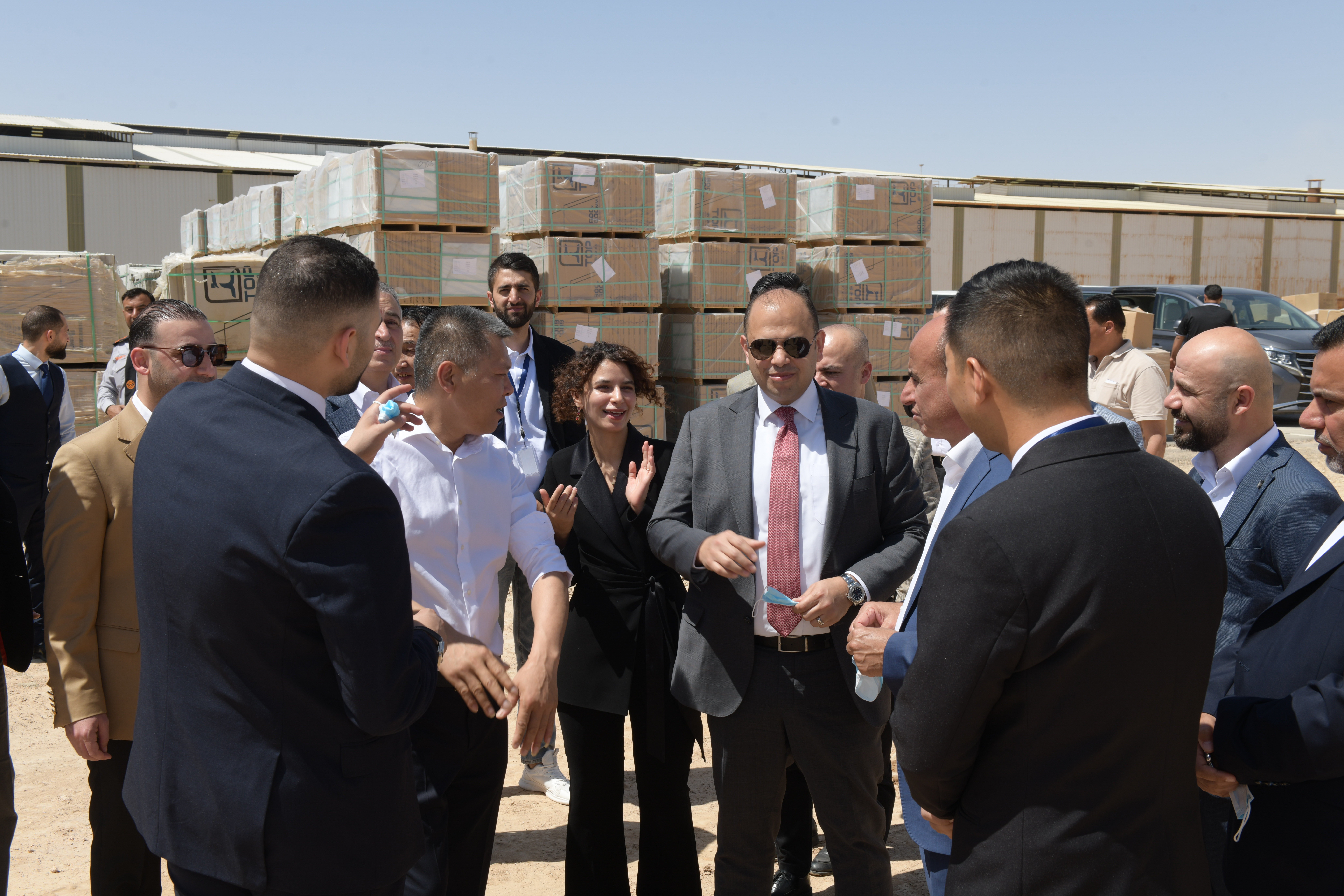 Team discussing an order with partners beside stacked export cartons