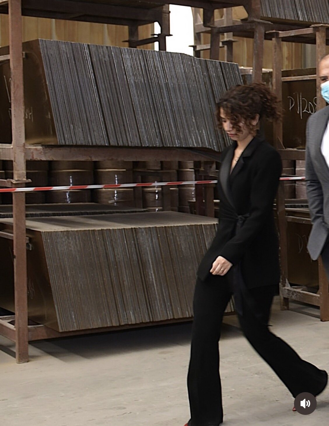 Team member walking past stacked tile bodies in the factory storage racks