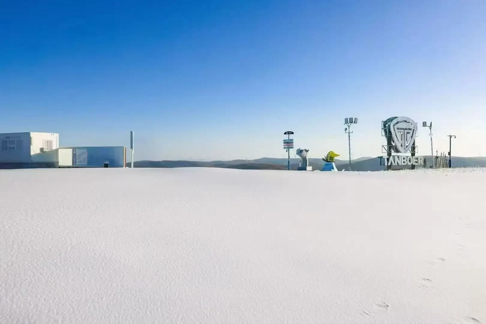 Fresh snow on the upper mountain under a clear blue sky
