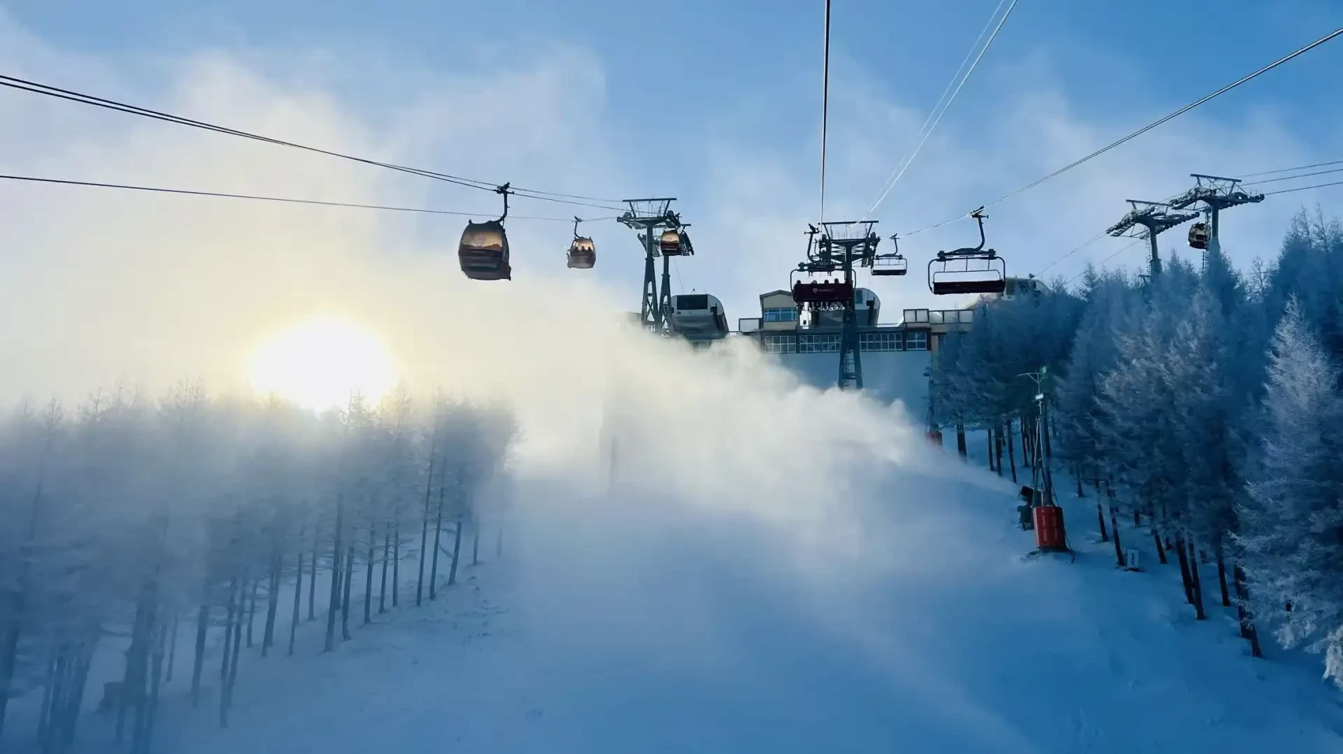 Gondolas and chairlifts climbing to the summit above the fog
