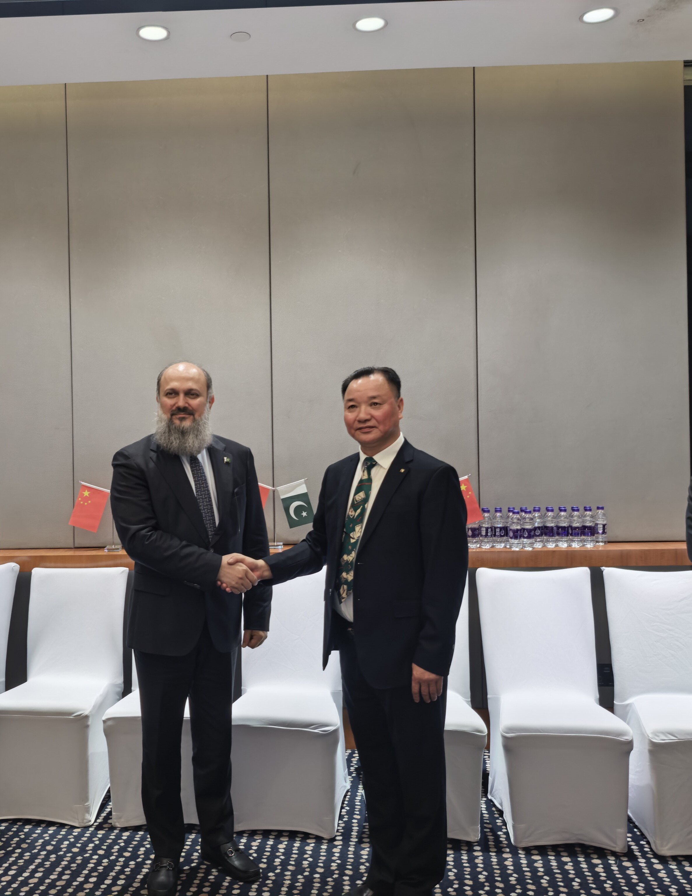 Chairman Wang Jin and Pakistan Commerce Minister Kamal shake hands for a photo