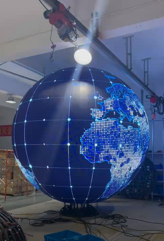 Sphere-shaped creative LED display showing a glowing earth in the workshop