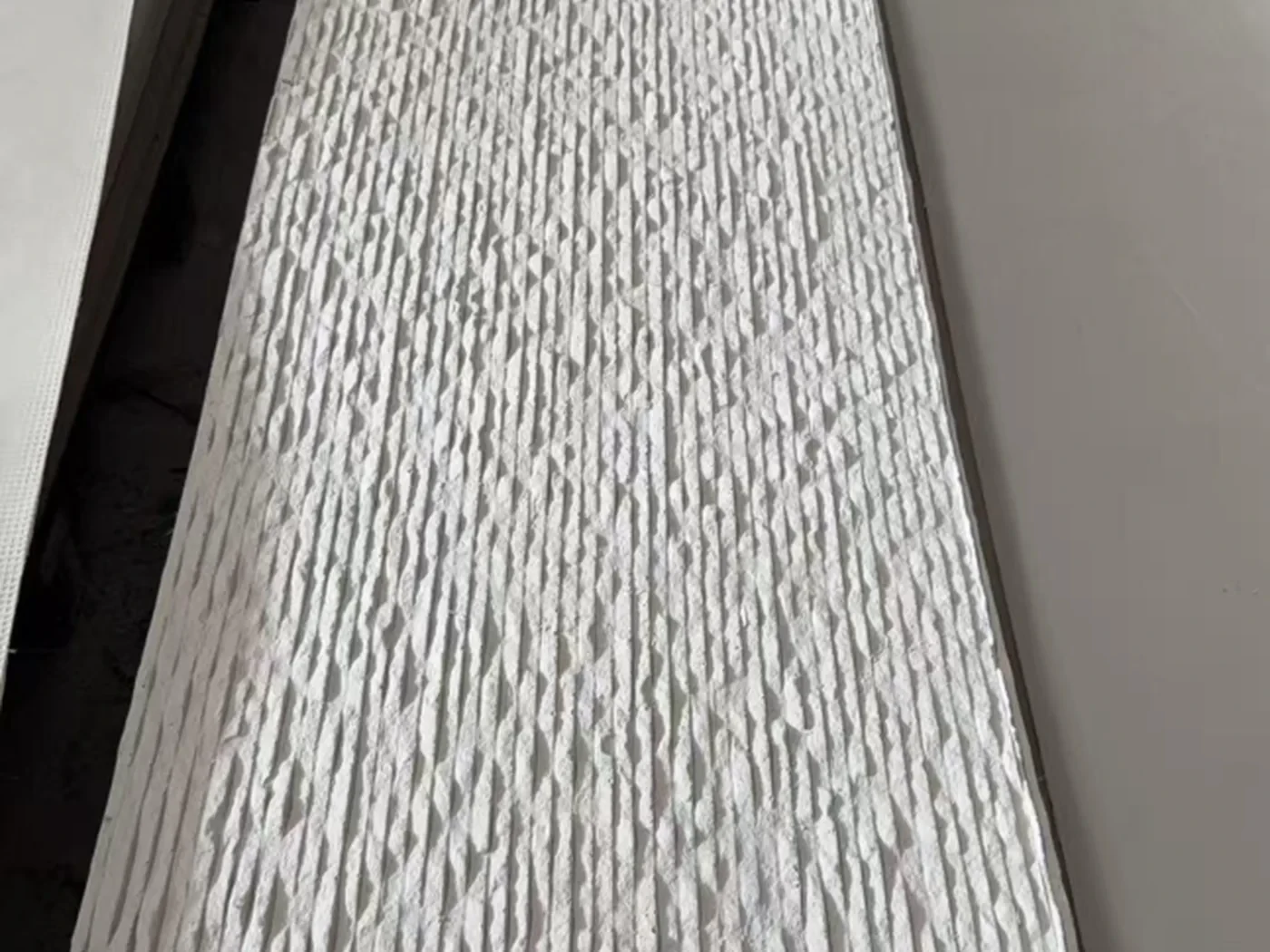 主推新品·3D纹理系列：柔韧石材基材，浅灰白波浪竖向肌理，样板色卡实拍用于室内墙面与背景墙选型