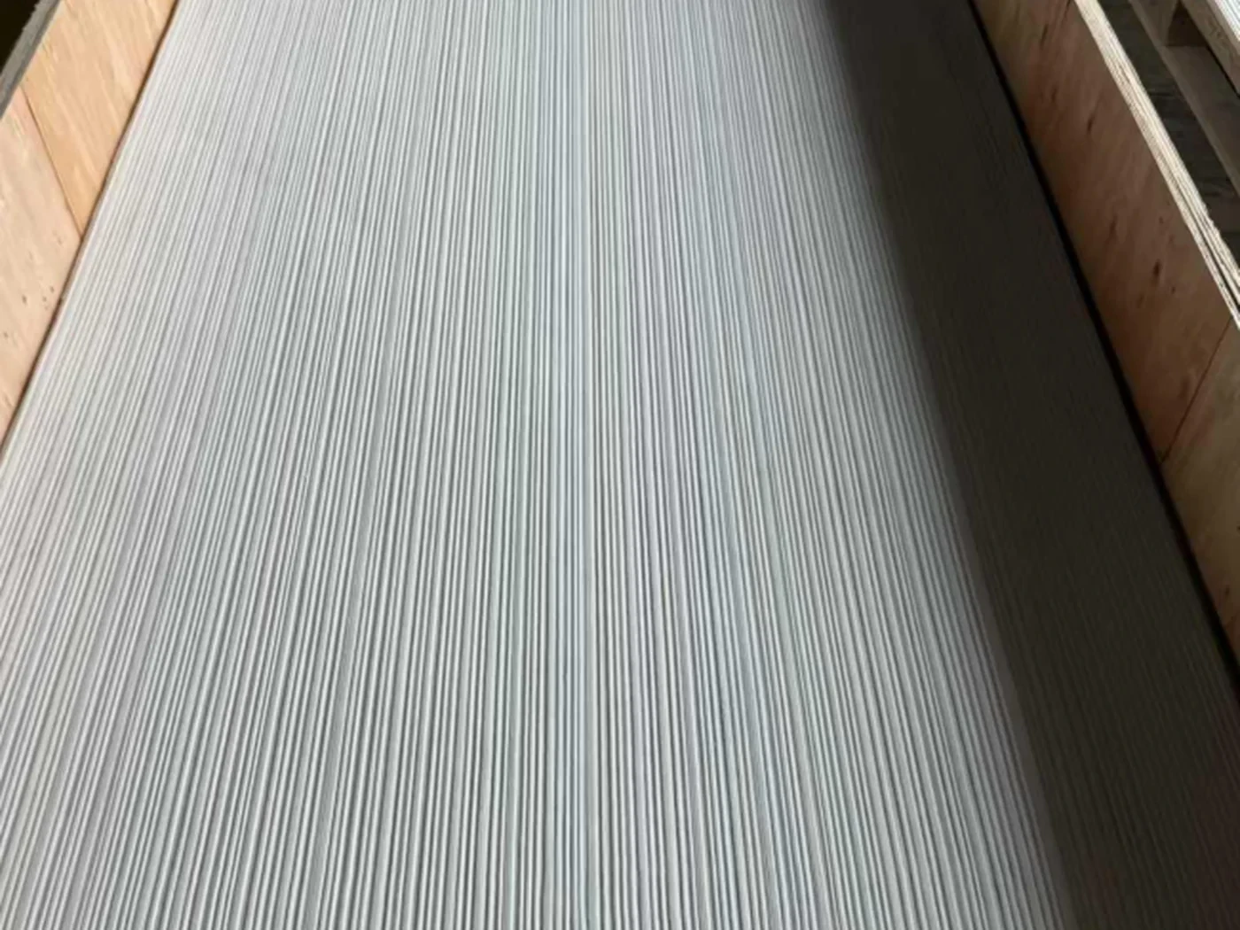主推新品·3D纹理系列：柔性石材表面呈浅灰白竖向细密条纹，样板色卡置于木质托盘中，用于室内墙面与背景墙选材参考