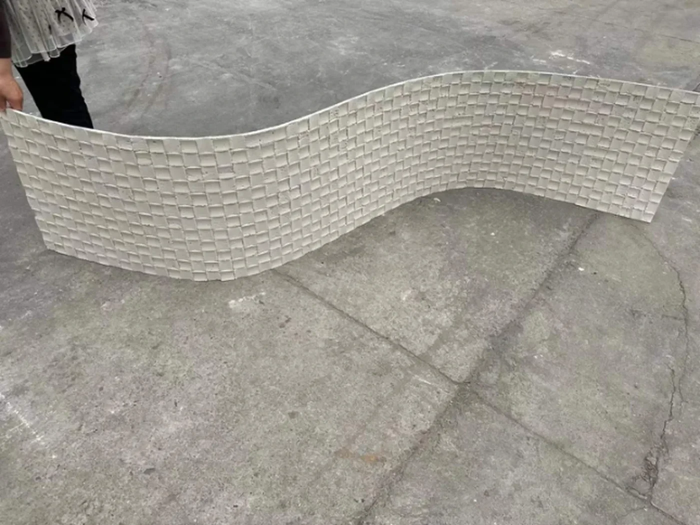 主推新品·3D纹理系列：柔性石材表面呈浅灰米色编织网格浮雕纹理，车间实拍中，呈柔韧弯折特性与立体肌理细节