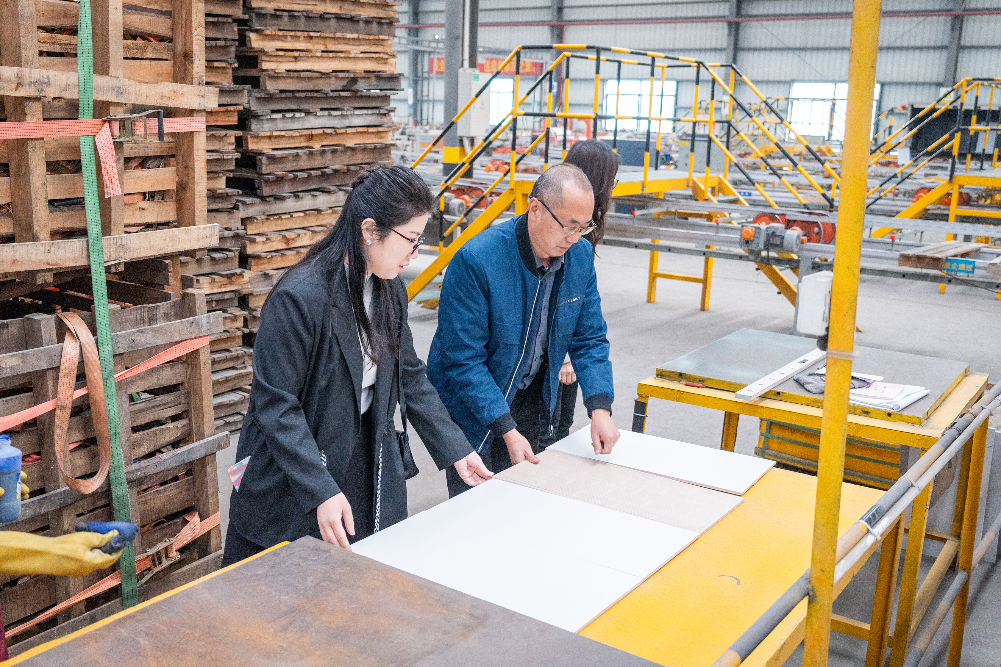 Client inspecting tile samples in factory