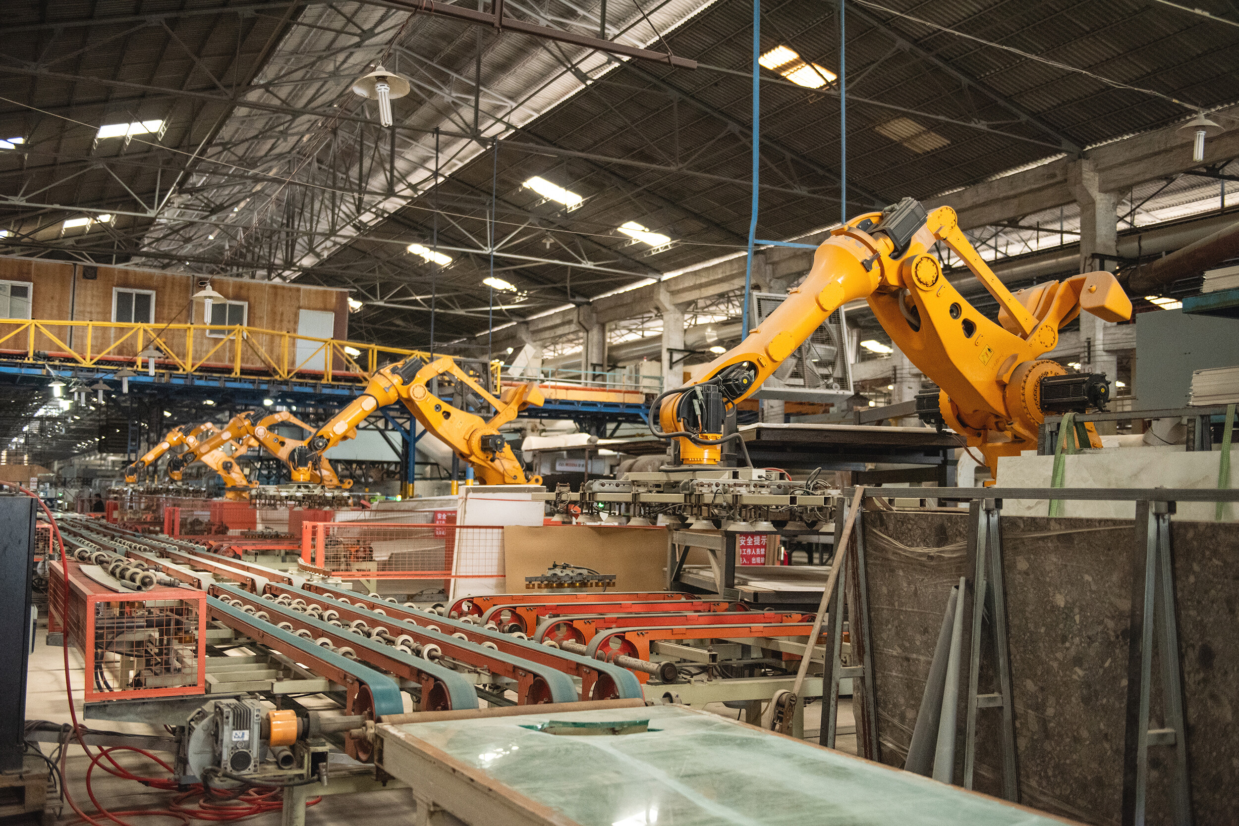 Orange robotic arms on automated production line