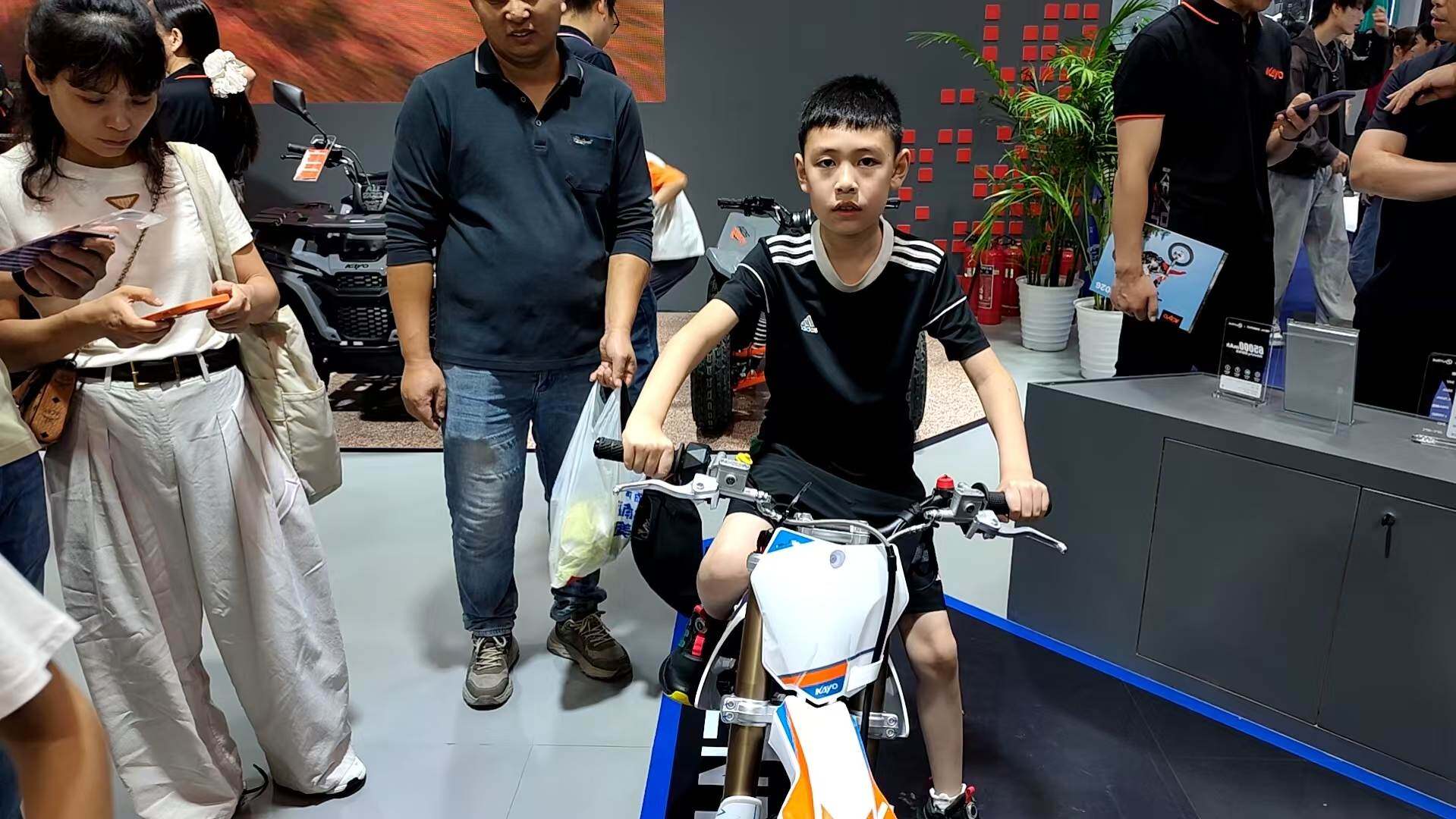 Young testers observe the product at the booth.