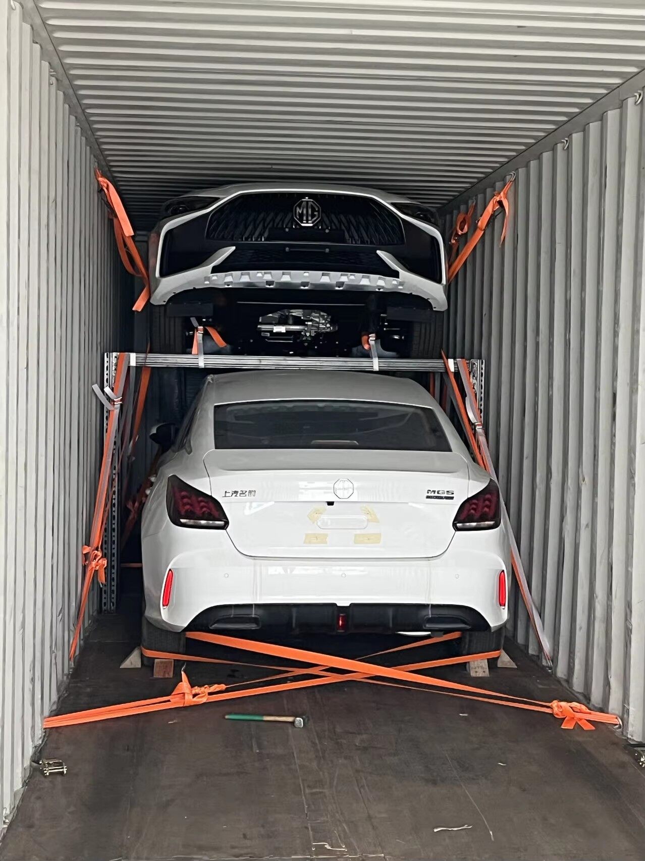 Cars loaded inside shipping container with orange straps