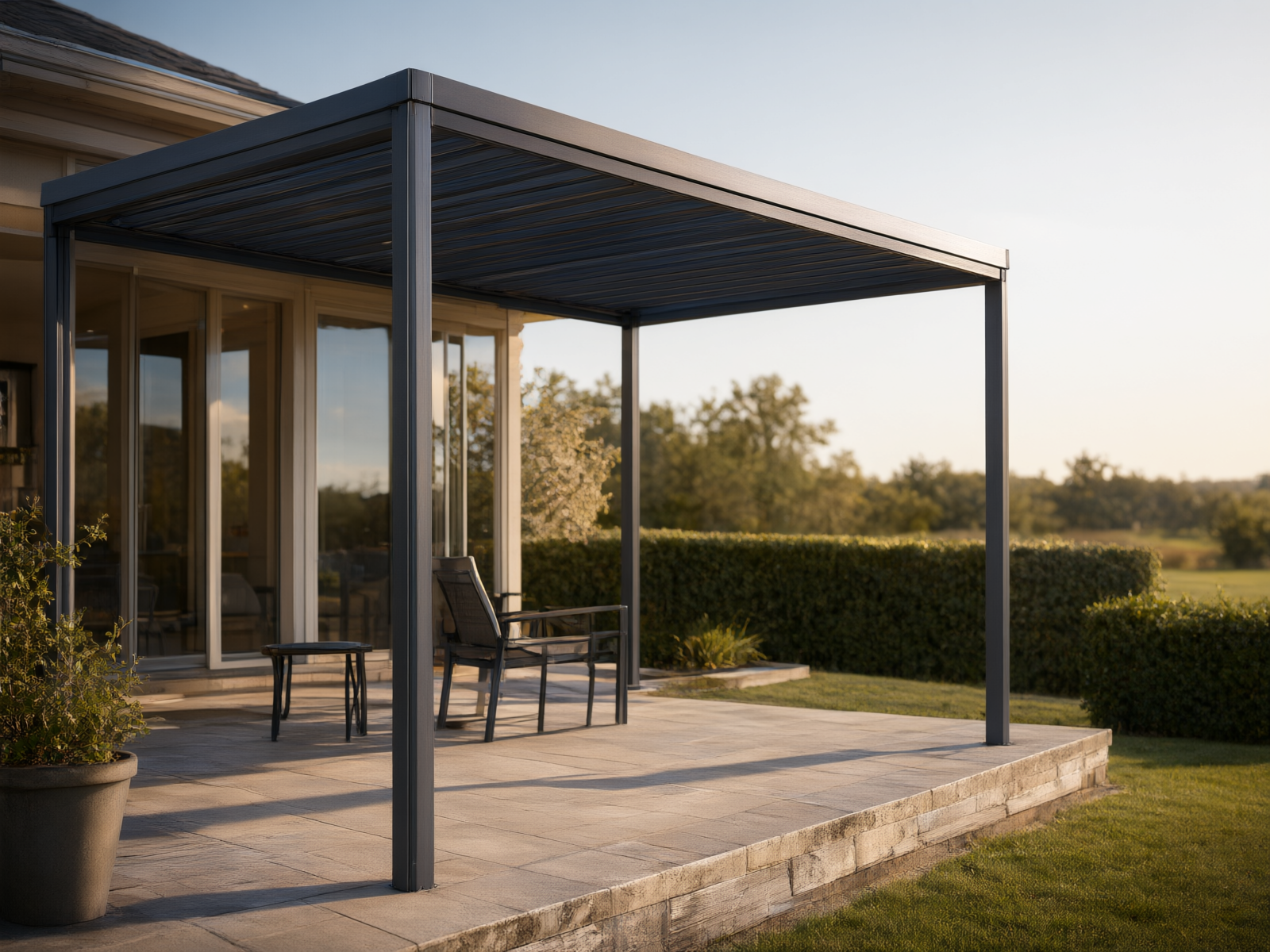 A modern residential backyard with an aluminum pergola system installed over a stone-tile terrace