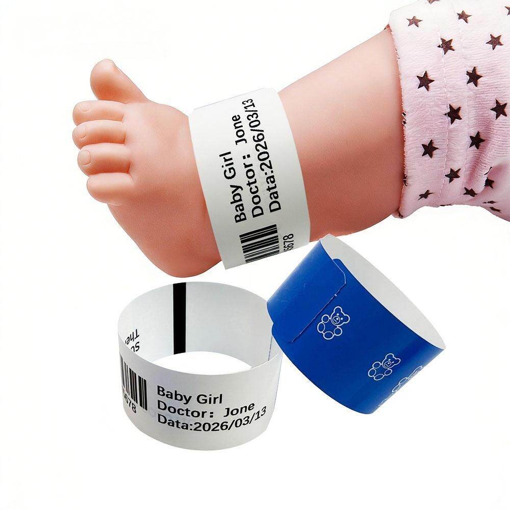 Newborn foot wearing a printed identification wristband beside blue and white baby wristbands.