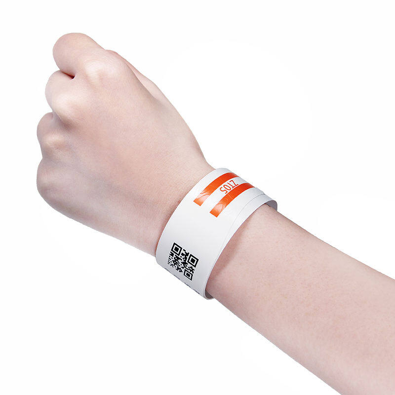 Patient wristband with QR code and orange stripe worn on wrist for identification and communication